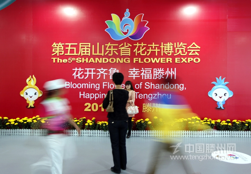 市民在第五屆花卉博覽會(huì)展牌前留影